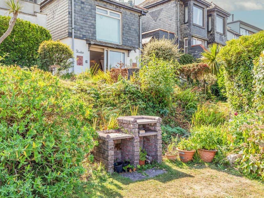 BBQ area in shared garden, with tables, chairs and stunning views | Studio Sea Urchin, Carbis Bay, near St Ives