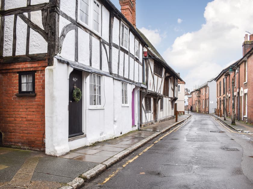 Exterior of property on Ivy Lane full of historic houses as well as a pub and coffee shop, leading to Canterbury walls / High Street. | Tudor Cottage, Canterbury