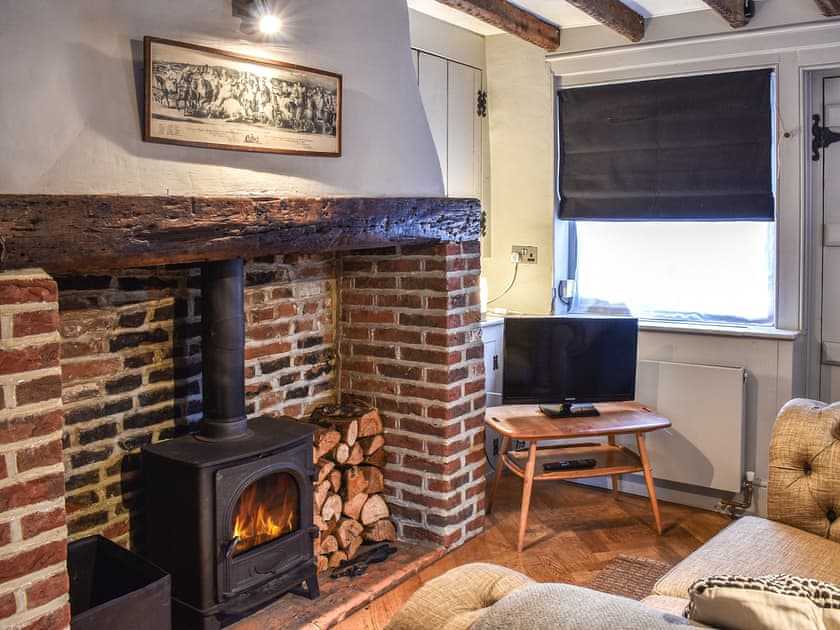 Living room with inglenook fireplace and stove | Tudor Cottage, Canterbury