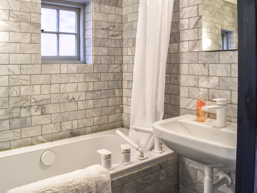 Bathroom with dual rainfall shower and pull out handset shower over bath. | Tudor Cottage, Canterbury