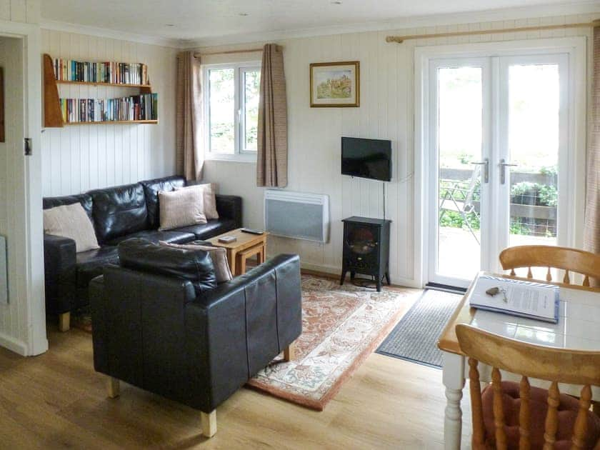 Cosy and comfortable living area with double doors to the terrace | Ash Lodge, Nawton, near Helmsley