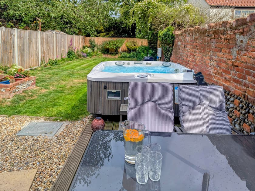 Fully enclosed rear garden with hot tub, decking and outdoor seating | Rosemary Cottage, Hickling, near Happisburgh