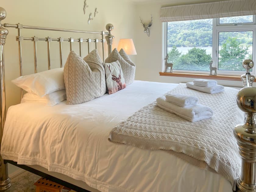 Luxurious master bedroom has spectacular views from its super-king pocket sprung bed through two picture windows | Tigh-na-Creige, Colintraive