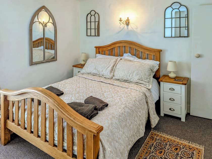 Solid oak double bed and door to bathroom and stairs | Trinity Cottage, Wells-next-the-Sea