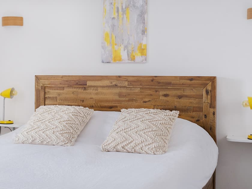 This double bedroom has a king size recycled oak bed and a thick premier mattress. At 11ft x 12ft plus an on-suite, it is cosy and comfortable | Old Quay, Newlyn