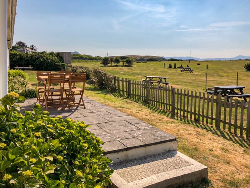 Delightful sitting out area with table and chairs | Maes y Mor, Criccieth, near Porthmadog