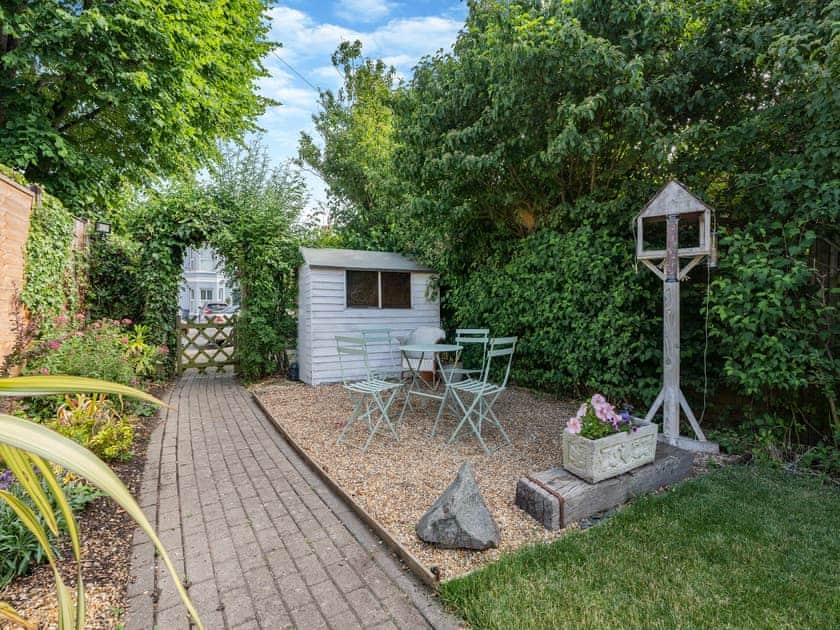 Seating area in garden with BBQ and tranquil sound of running water from the neighbouring carp pond. | Greenfield Cottage 1866, Worthing