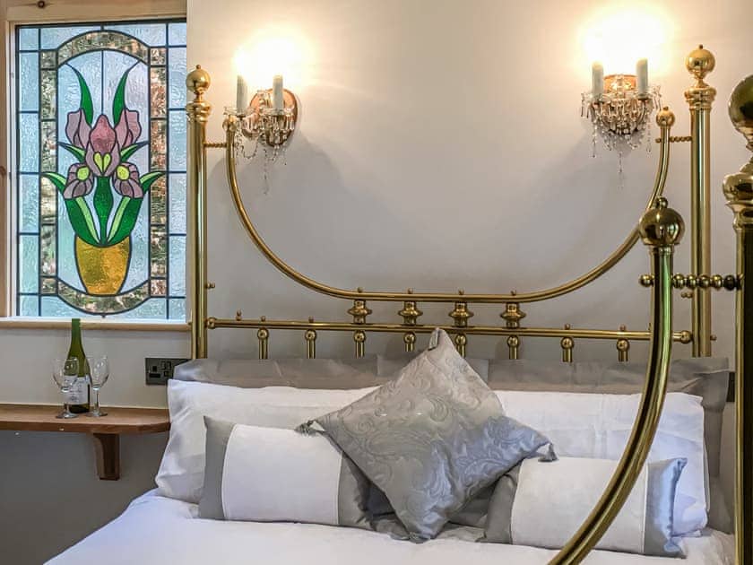Beautiful stained glass window and crystal wall lights in the bedroom  | The Escape, South Hill, near Tamar Valley