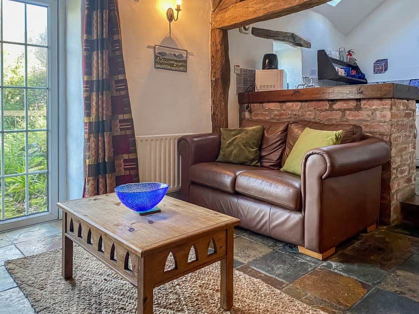 Tile-floored living space with access to the garden | Birkerthwaite Stable - Birkerthwaite Cottages, Eskdale