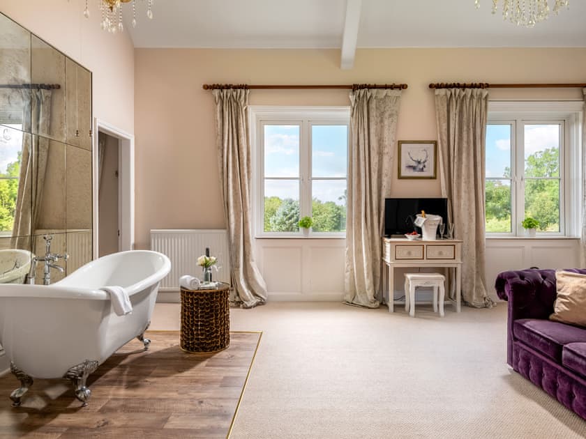 Spacious and roomy master bedroom with standalone roll top bath | Downwood Vineyard, Blandford
