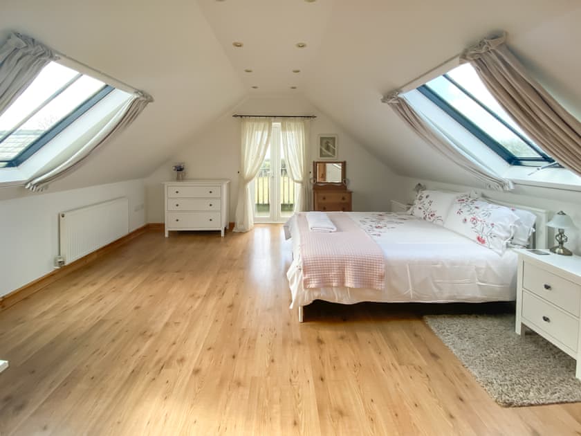 Master bedroom with Kingsize bed and en-suite  | Sgubor Wennol Ty Du, Llannor, near Pwllheli
