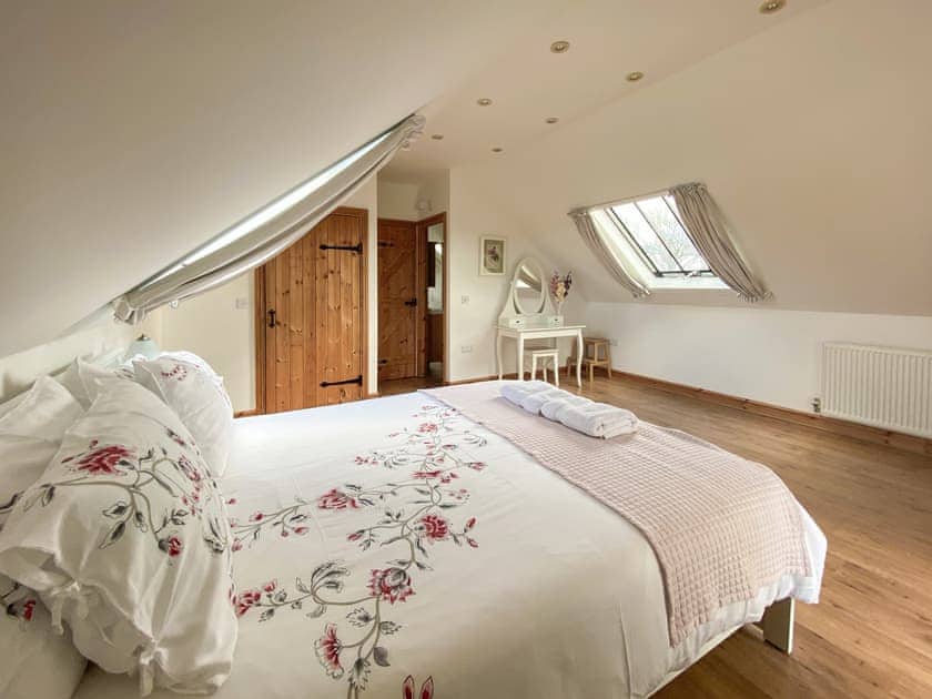 Master bedroom with Kingsize bed and en-suite  | Sgubor Wennol Ty Du, Llannor, near Pwllheli