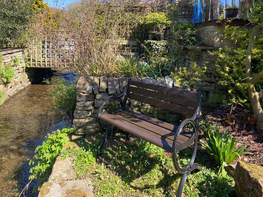 Bench by the stream in the back garden | Holly Cottage, Langley near Buxton