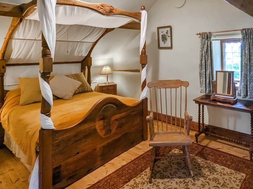 Romantic bedroom with rustic four-poster bed | Harvest Cottage, Pen-y-Cae, near Ruabon