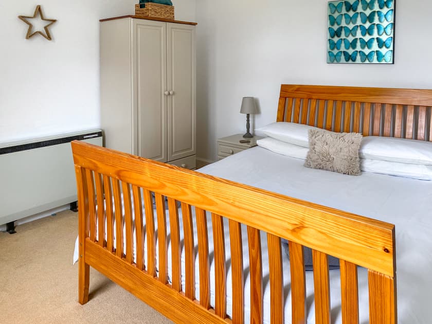 Spacious, bright and relaxing ground floor bedroom featuring king size sleigh style bed | Kirnan Cottage, Kilmichael Glassary, near Lochgilphead