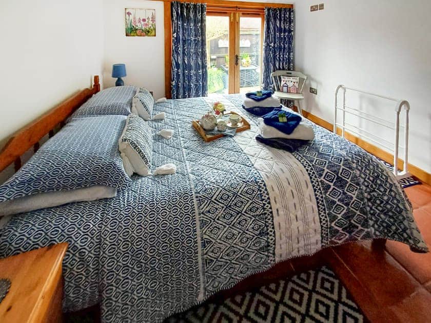 Double bedroom French doors leading to the courtyard | Meadow Barn, East Burton, near Wool