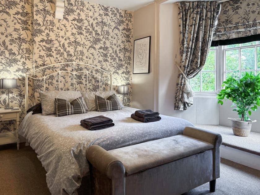 Spacious double bedroom with king size vintage style Cast Iron bed | Nell’s Cottage, Bridlington