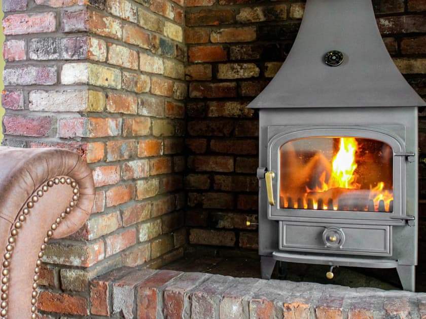 Warming wood burner in living room | Green Lane Cottage, Aberhafesp, near Newtown