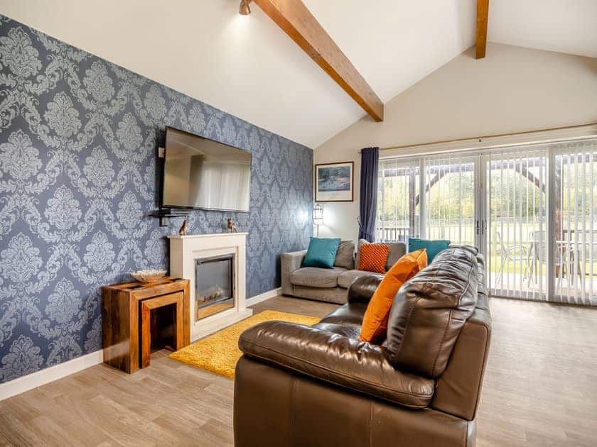 Comfortable living space with patio doors to the verandah | Humphrey-Basil Lodge - Birchdale Lodges & Alpaca’s, Norton Disney, near Lincoln