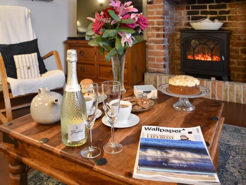 Cosy living room with electric wood burner | White Stones Cottage, Caister-on-Sea, near Great Yarmouth