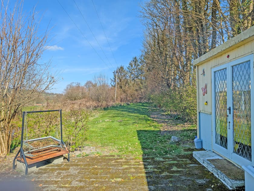Grass area beside summerhouse, including BBQ | Rosie - Tanyrallt Holidays Lets, Llanybydder, near Lampeter