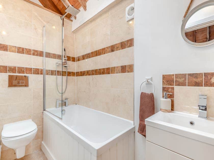Bathroom with shower over bath | The Dairy - Milton End Farm Barns, Arlingham, near Frampton-on-Severn
