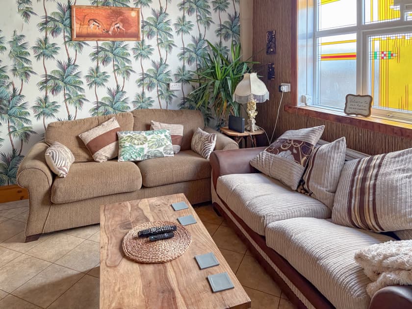 Jungle room tv area with two comfortable couches | Lilac Villa, Skegness