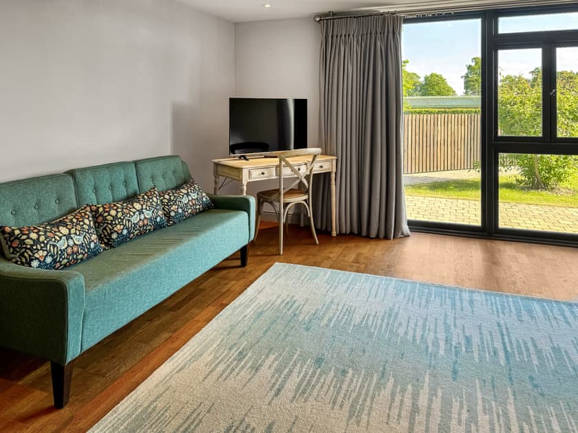 Bedroom one, seating, TV and view from your bed | Barn Owl Cottage - Home Farm Retreats, Kirk Hammerton, near York