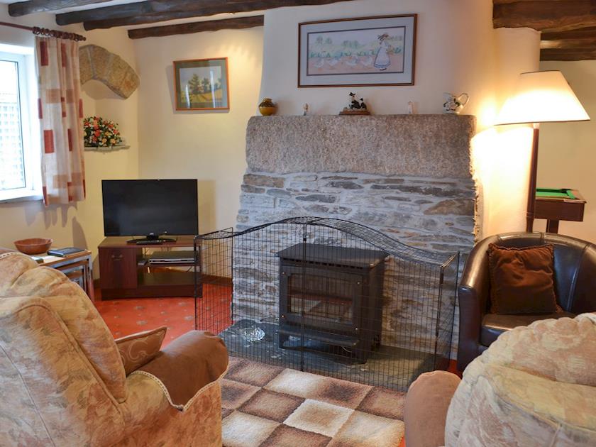 Living area with feature fireplace home to a woodburner | Haycombe Cottage, Camelford