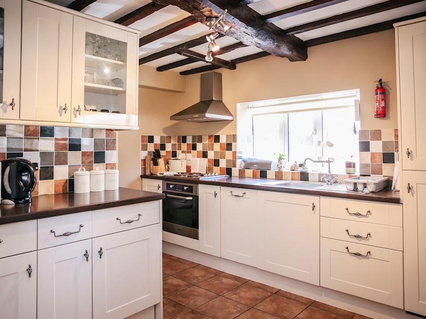 Well-equipped fitted kitchen with traditional wooden-beamed ceiling | Farmhouse Wing - Millmoor Farm, Bickley, near Malpas 