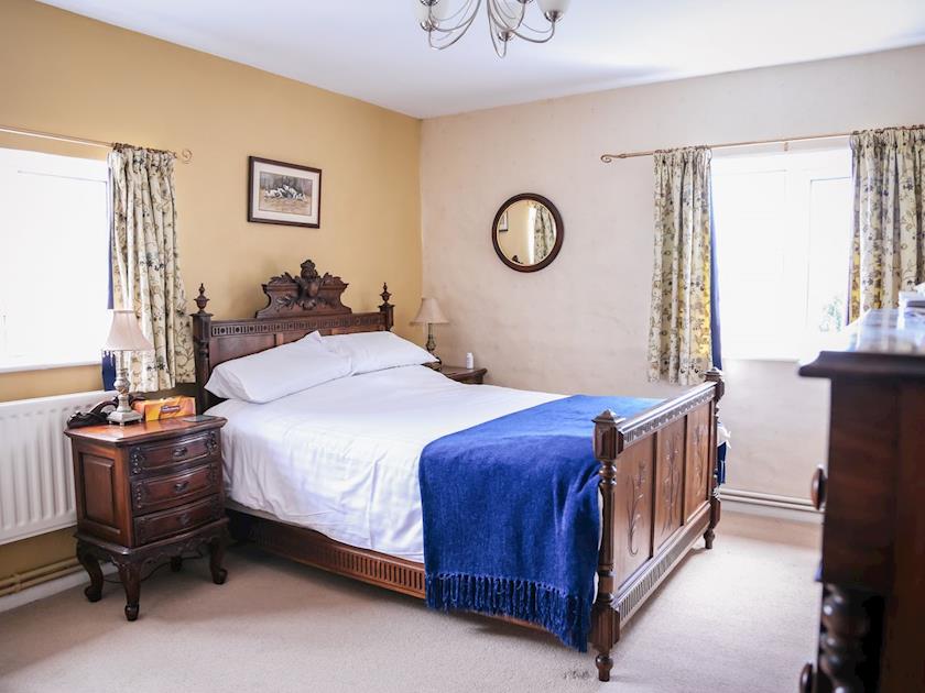 Spacious double bedroom with heritage carved wooden bedframe | Farmhouse Wing - Millmoor Farm, Bickley, near Malpas 