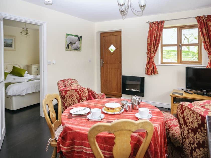 Dining and living area with wall mounted flame effect fire and flat screen TV | Carter’s Lodge - Millmoor Farm, Bickley, near Malpas