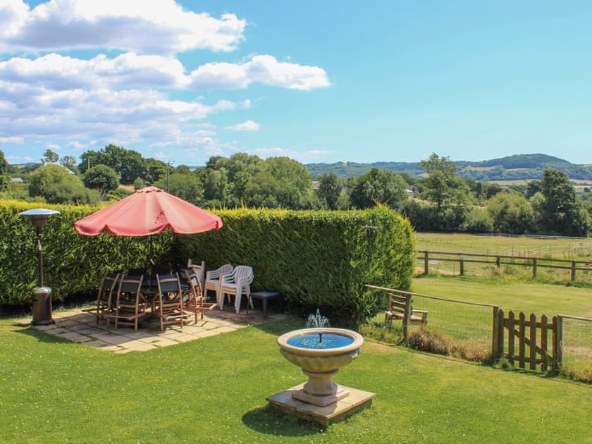 Garden with BBQ, fountain, views, play area and table, chairs and umbrella | Stable Cottage, Colyford, near Seaton