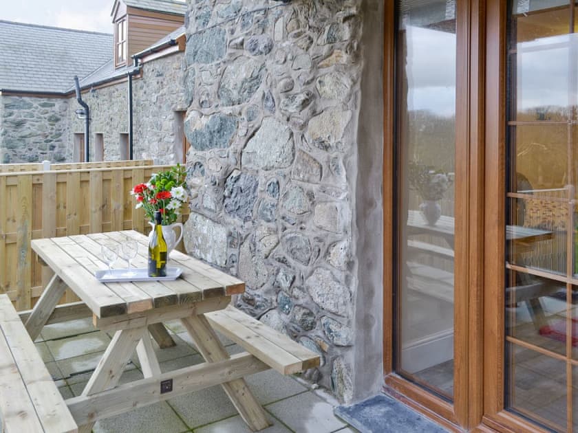 Outdoor seating on patio | Rhiwal Kitty - Trehwfa Cottages, Bodedern, near Holyhead