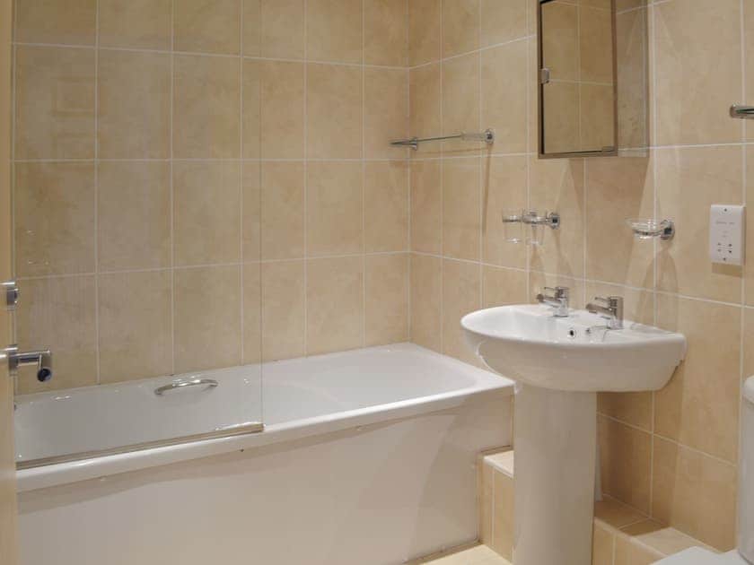 The fully tiled bathroom has a shower over the bath | Apartment 6 - Astor House, Torquay
