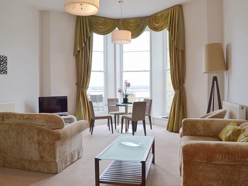 Grand furnishings and opulent decor frame the large picture windows in the living room | Apartment 8 - Astor House, Torquay