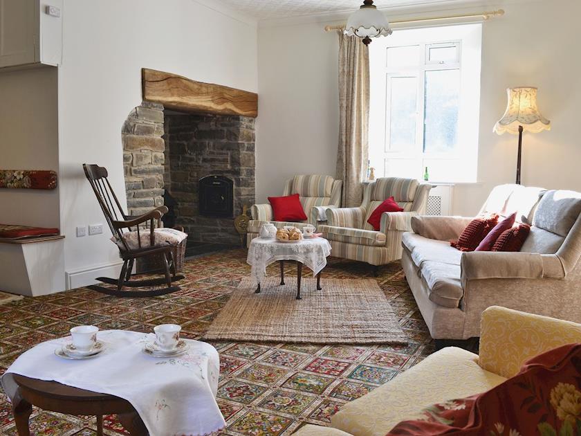 Large living room with wood-burning stove in inglenook fireplace and games area | Brynog Mansion Farmhouse, Lampeter, near Aberaeron