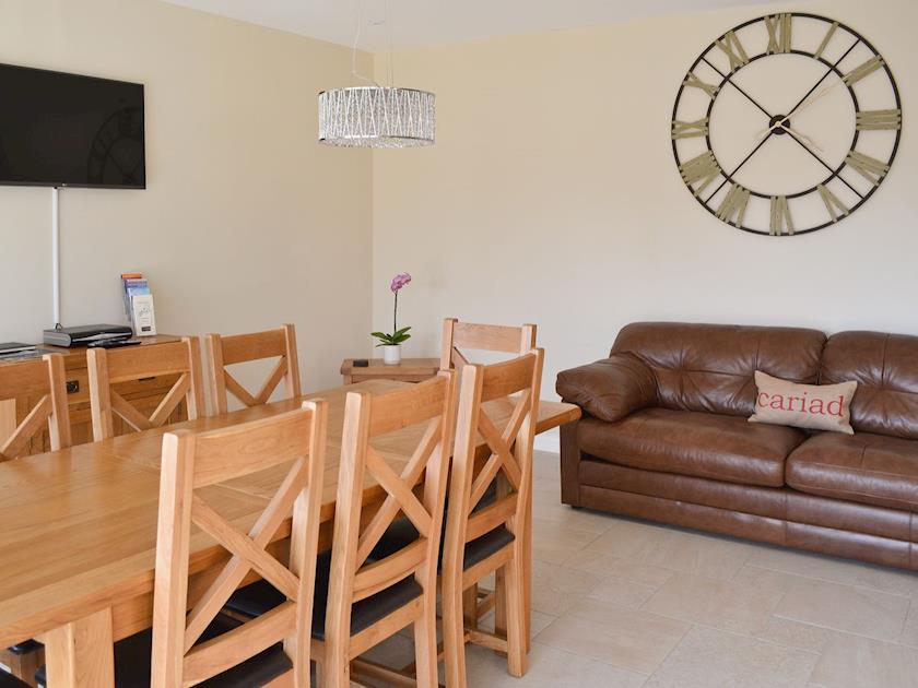 Dining room/kitchen with breakfast bar, TV, tiled floor and bi-fold doors to patio | Birchfield, Rhuallt, near St Asaph