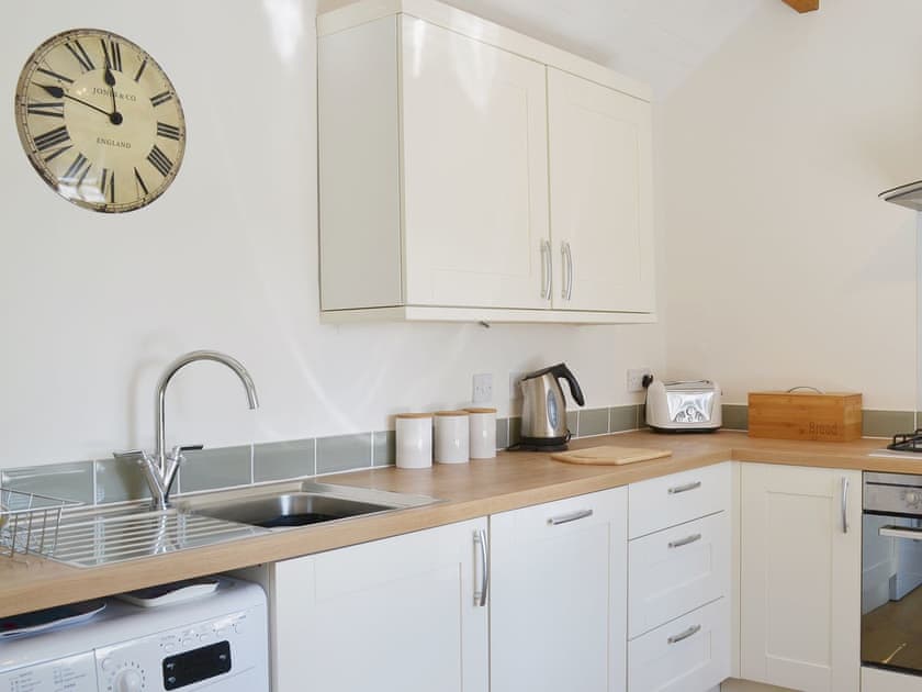 Spacious and bright, the kitchen has exposed woodwork and sloping ceilings | Garden Cottage, Ugborough, near Ivybridge