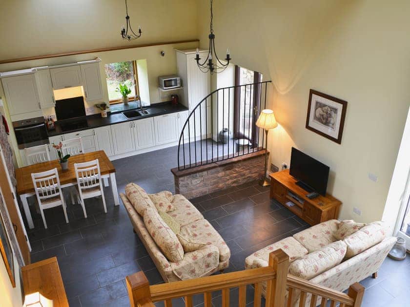 Open plan living space with beams and tiled floor. | Mere Croft, Sowerby Row near Penrith