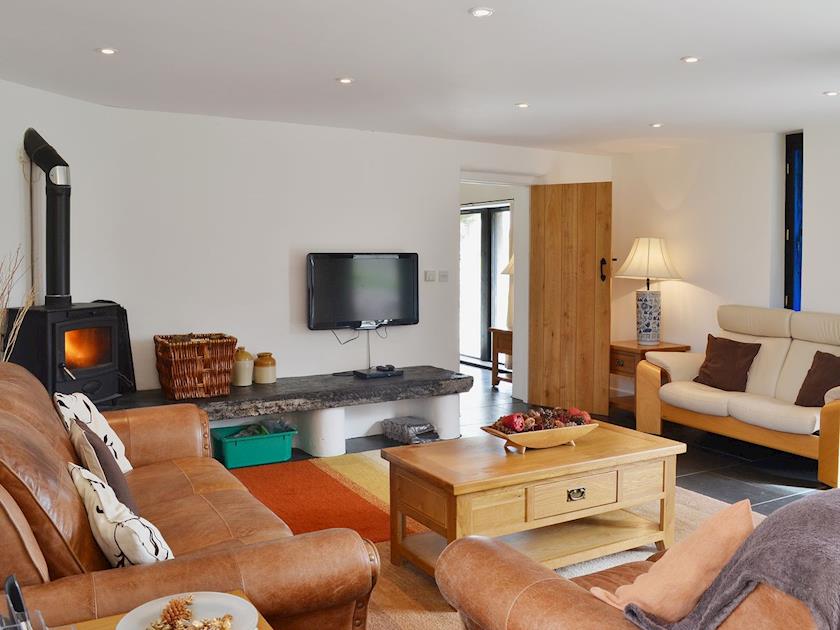 Spacious slate floored living room with woodburning stove | Y Stabl - Cennen Cottages, Bethlehem
