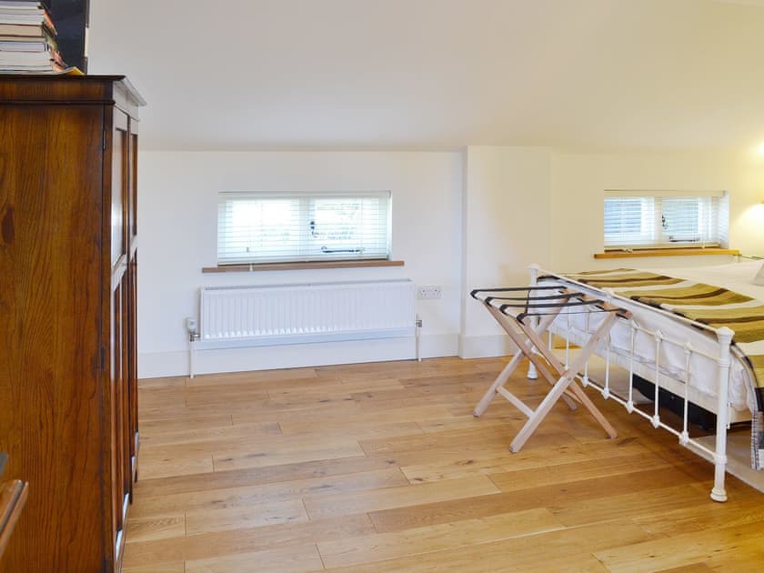 Oak floors and matching furniture make the bedroom a warm and welcoming room | The Gardener’s Cottage - Canterbury Cottages, Shatterling, near Canterbury