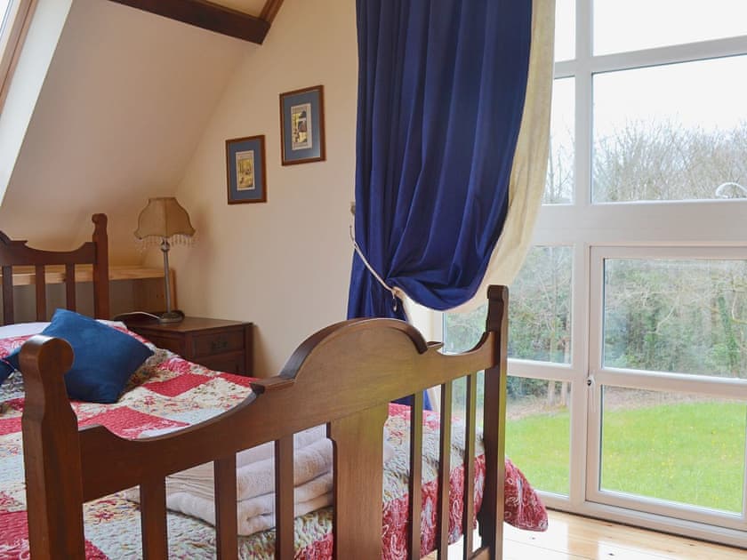 A large full length window lets light flood into the double bedroom | Yr Wyddfa - The Old School, Caeathro, Caernarfon