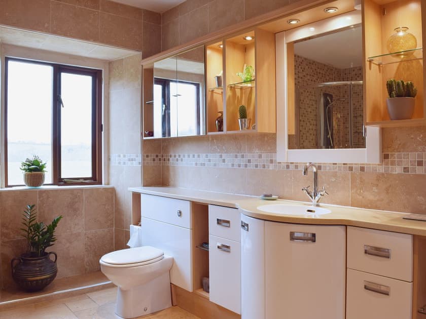 The bathroom is fully tiled and well lit with a shower cubicle | Tan Y Castell, Llanmill, near Narberth