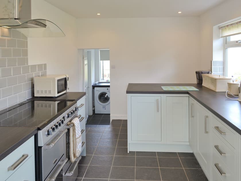 Well-equipped fitted kitchen leading to utility room | Penteryfn, near Holyhead, Isle of Anglesey
