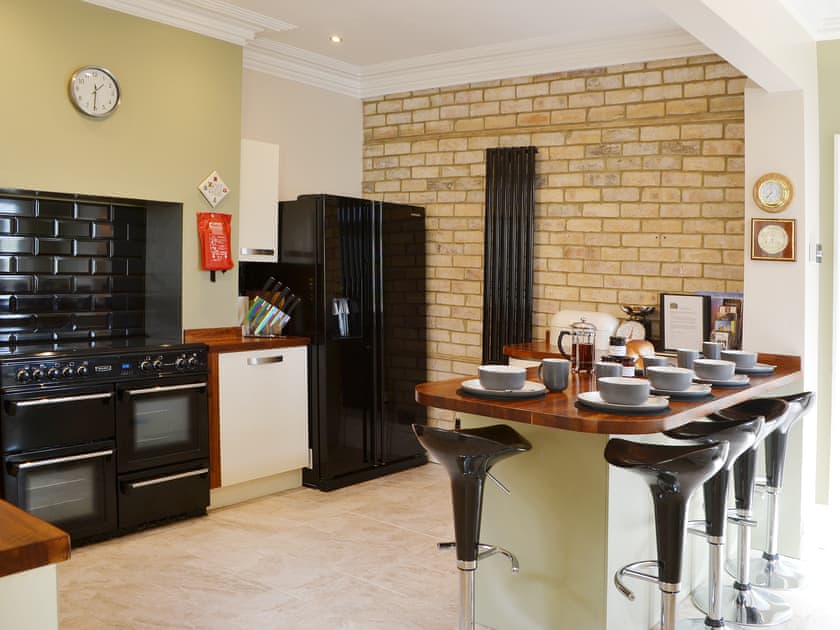 The feature brick wall, American style fridge freezer and range cooker gives the kitchen a professional fell | Island View, Amble