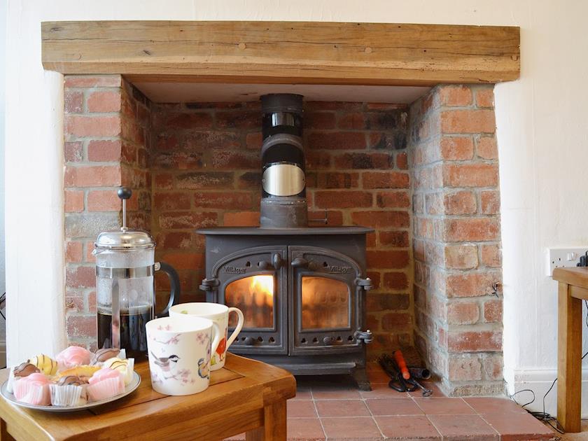 Woodburning stove sitting snugly in the splendid fireplace | The Old Post Office, Myddfai, near Llandovery