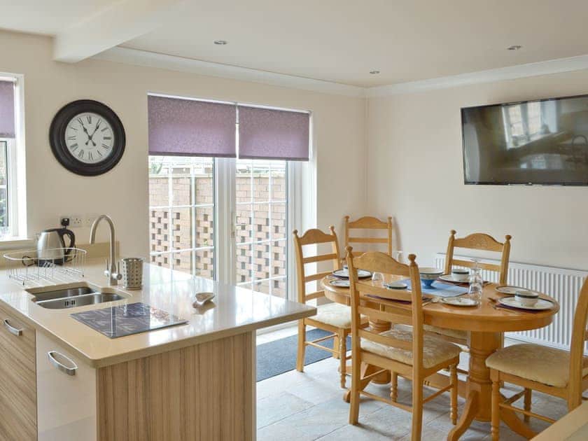 Stylish dining area of kitchen with French doors to rear courtyard | Smitten Cottage, Rhyl