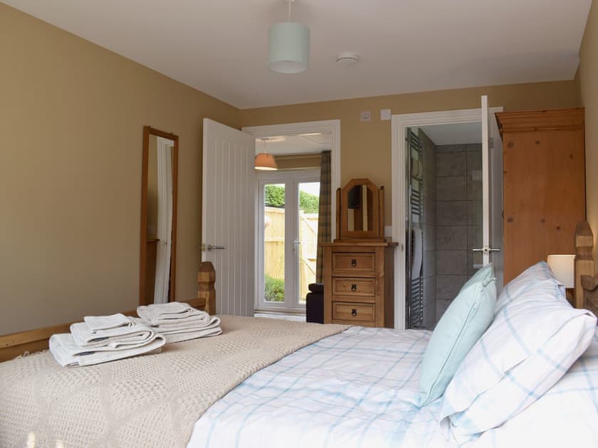 Bedroom with kingsize bed and en-suite shower room | The Old Boat Store, Totland, near Freshwater