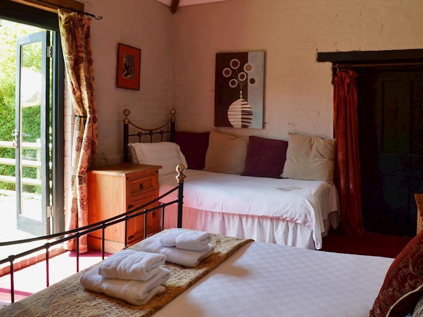 The ground floor double has a single bed for additional sleeping arrangements and patio doors that lead on to the garden | Brook Barn - Brook and Meadow Barns, Shobley, Ringwood